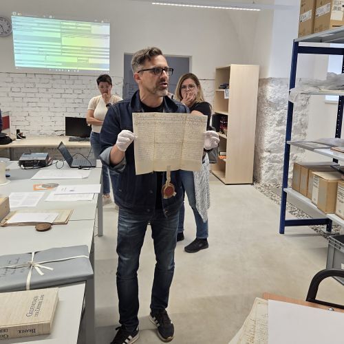 Archivdirektor Klaus Birngruber zeigt den äußerst interessierten KollegInnen eine Urkunde mit Sigel