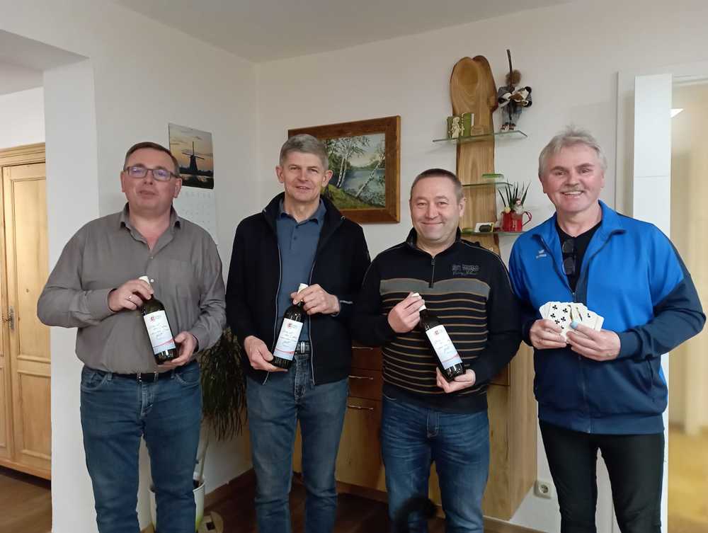 Vier Teilnehmer des traditionellen Tarokierens in Reichenthal mit dem KMB-Wein in der Hand