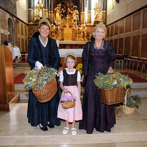 in der rund 700 jahren Alten Stadtpfarrkirche in Gmunden - immer am 15. August verkaufen die Goldhaubenfrauen Kr?uterbuschen - am Foto:Obfrau Maria Wicke links mit Enkerl Clara Sophie und Rechts Angela P?schel