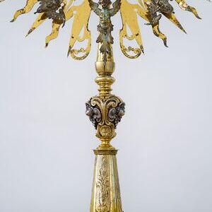 Die Monstranz  stammt aus der Zeit 1630-1640 und ist Silber vergoldet. Hinweis auf die Datierung ist das Augsburger Beschauzeichen 'GE' (Georg Ernst). Ihre Besonderheit ergibt sich durch die Gestaltung mit Cheruben, Engeln, die in der biblischen Über