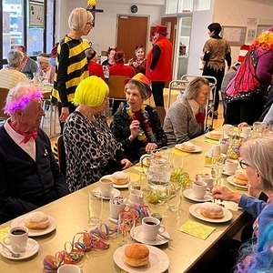 verkleidete Personen sitzen beim gedeckter Tisch