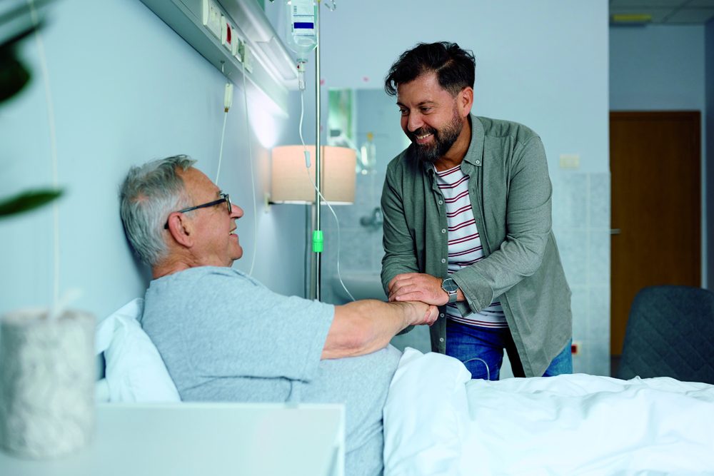 Ein Krankenhaus besuch eines Mann bei einem Bettlägigen