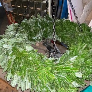 Fertig! Fleißige Hände binden den großen Kranz für die Kirche.