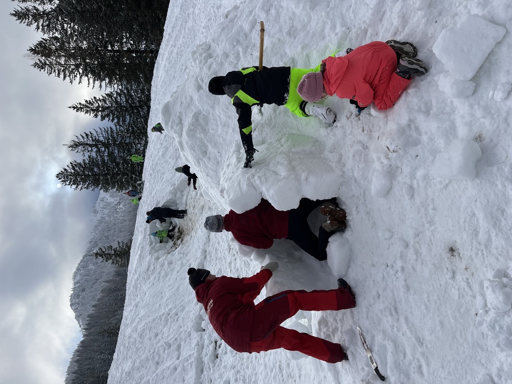 Kinder bauen ein Iglu mit voller Begeisterung