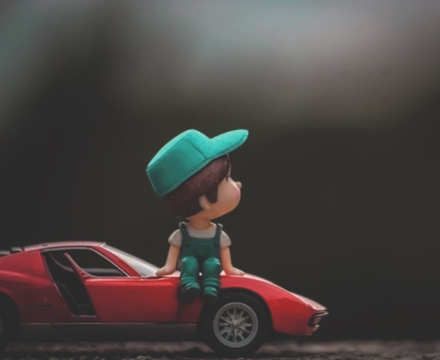 Kind sitzt auf einem Rennauto