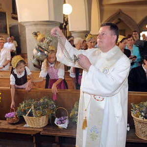 in der rund 700 jahren Alten Stadtpfarrkirche in Gmunden - immer am 15. August verkaufen die Goldhaubenfrauen Kr?uterbuschen - am Foto: Pfarrer Gerald Gayrhofer segnet die Blumen und Kr?uter
