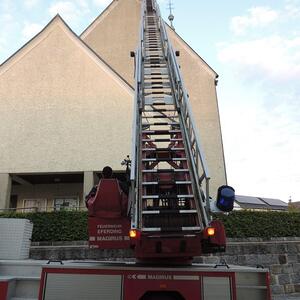 Feuerwehr repariert Kirchendach