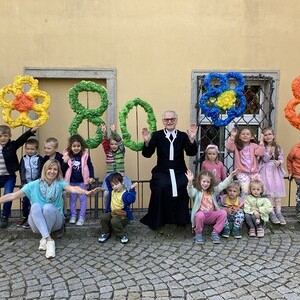DIe Kindergartenkinder gratulierten zum 80. Geburtstag von Pfarrer Engelbert Leitner