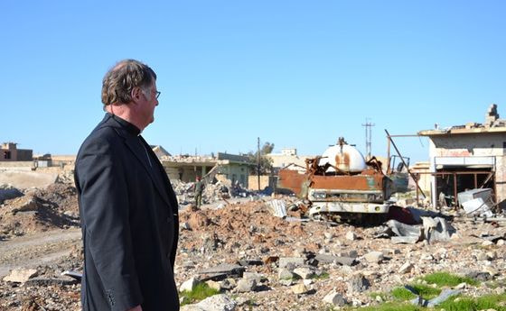 Bischof Manfred Scheuer blickt auf die Ruinen der zerstörten Christenstadt Batnaya.