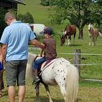 Vater und Kind beim Ponyreiten