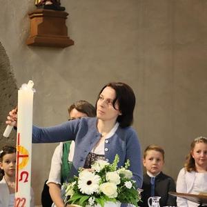 Die Tischmütter überreichen den Kindern die brennenden Taufkerzen.