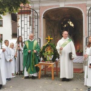 Diakon Martin Rögner segnet die Erntekrone.