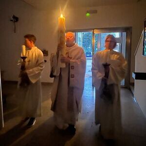 Die brennende Kerze wird in die dunkle Kirche getragen