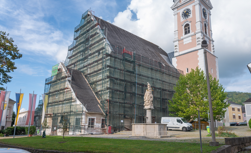 Die Fassade der Pfarrkirche Kirchdorf an der Krems weist große Schäden auf und wird von Fachkräften restauriert