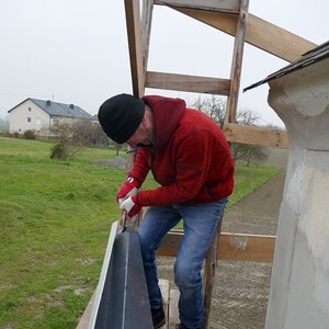 Günter montiert die  Dachrinnen.