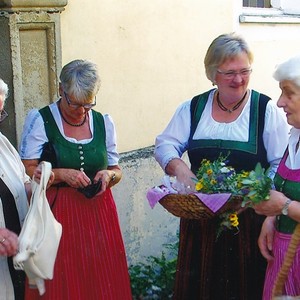 Goldhaubenfrauen beim Verkauf von Kräuterbüscherl