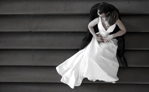 Bride and groom sitting on a wide staircase.Braut und Bräutigam auf einer großen Treppe sitzend.