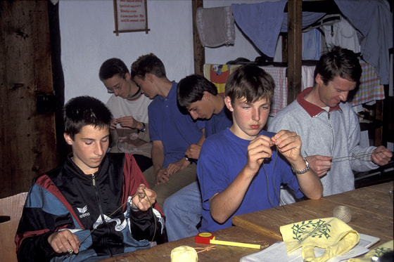 das diffizile Knüpfen des Halstuchknotens aus einem Stück: Zopfring, darüber Makramee