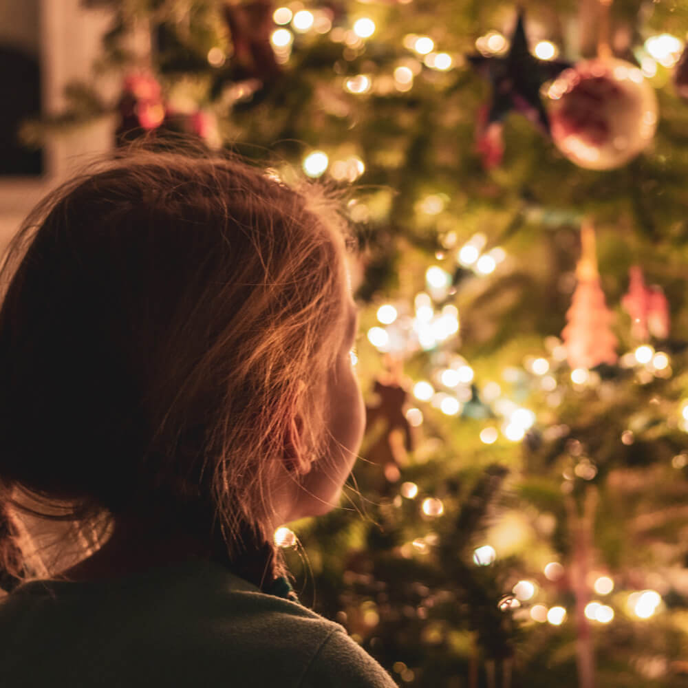 Mädchen vor dem Weihnachtsbaum