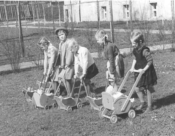 Mädchen beim Puppenwagenschieben / © Caritas 80 Jahre im Dienst der Kinder