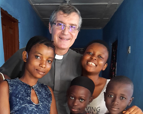 Salesianerpater Jorge Crisafulli, Direktor des Kinderschutzzentrums Don Bosco Fambul in Freetown, mit jungen Schützlingen