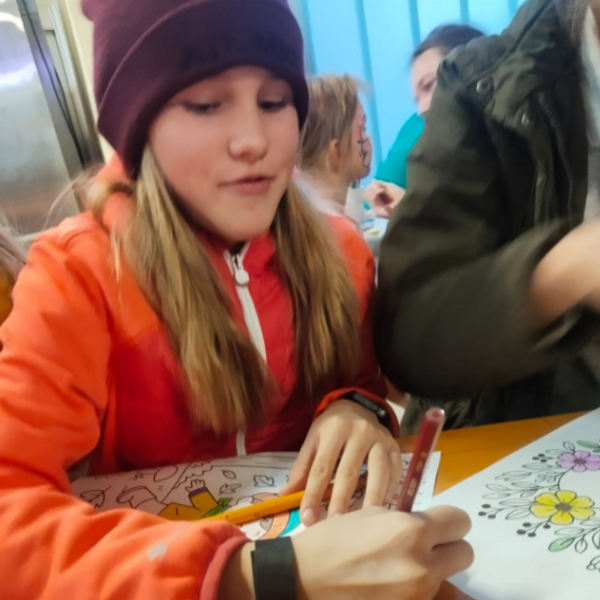 Mädchen das fröhlich ein Bild ausmallt