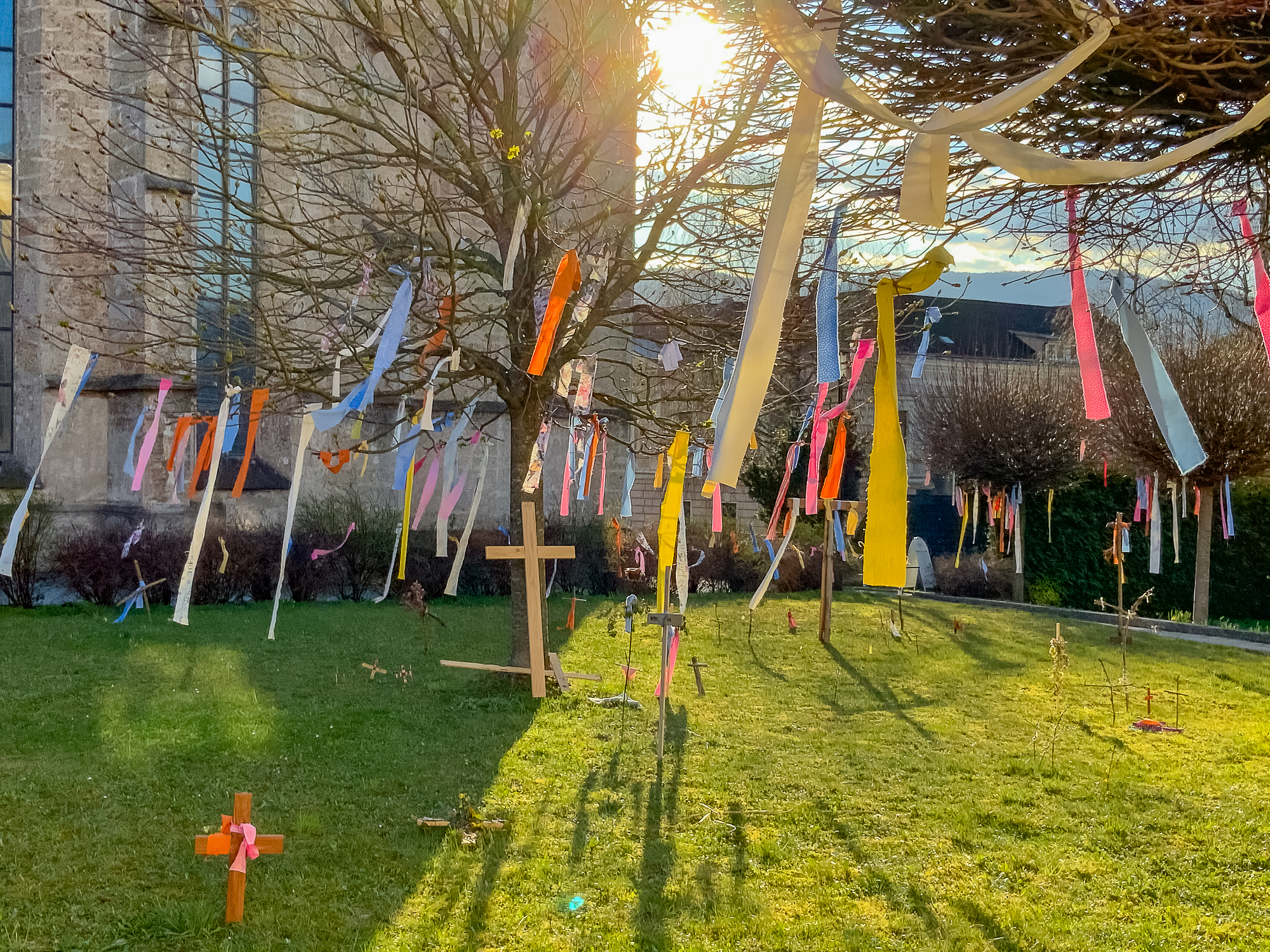 Osteraktion der Pfarre Kirchdorf an der Krems. Bis Karfreitag wurden im Garten des Pfarrhofs verschiedenste Kreuze aufgestellt, die das Leid zur Sprache bringen. Zu Ostern wurden diese mit bunten Bändern geschmückt als Zeichen, dass es im Leiden eine