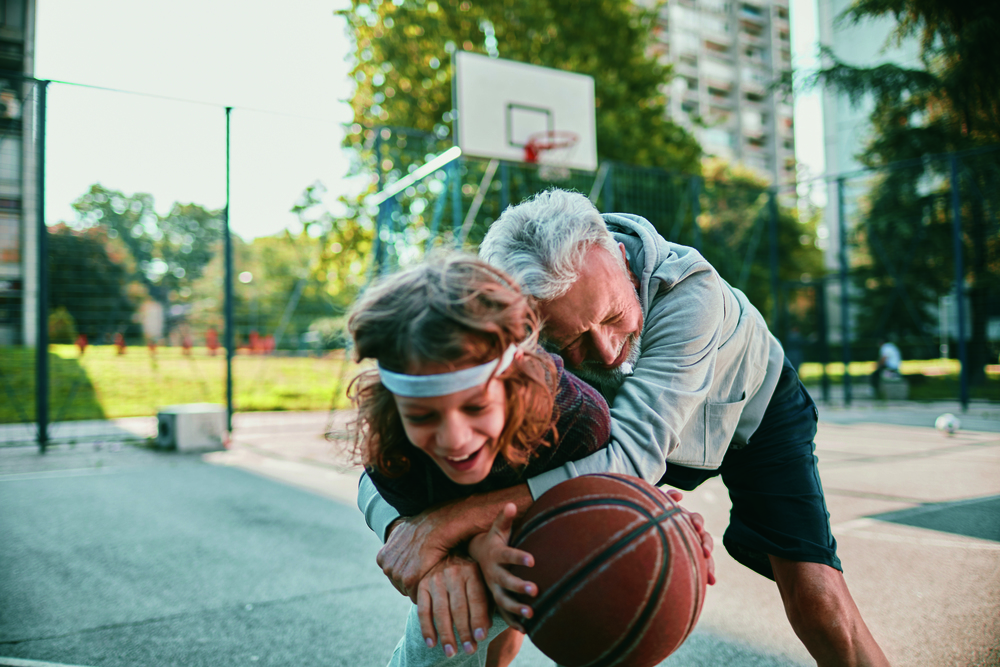 Ein Großvater spielt mit seinem Enkelkind Basketball