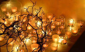 brennende Teelichter hinter einem Trauerweidenzweig
