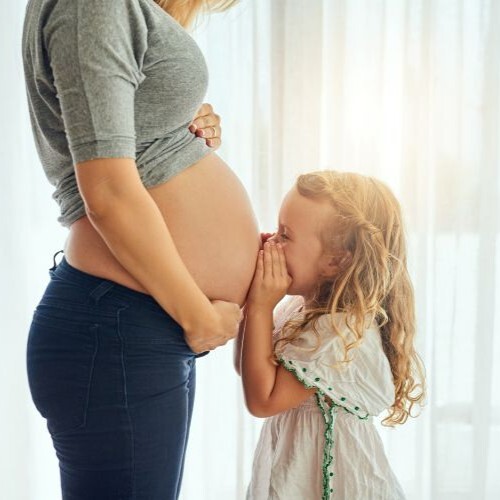 Cropped shot of a little girl whispering to her mother's pregnant belly