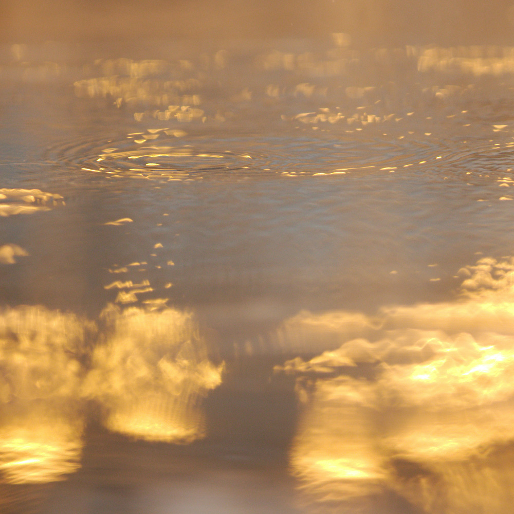 Spiegelung der Sonne und der Wolken