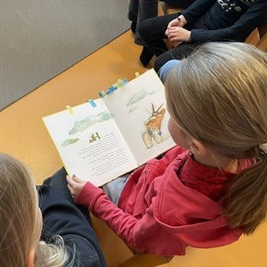Schulkinder lesen mit den Kindergartenkindern