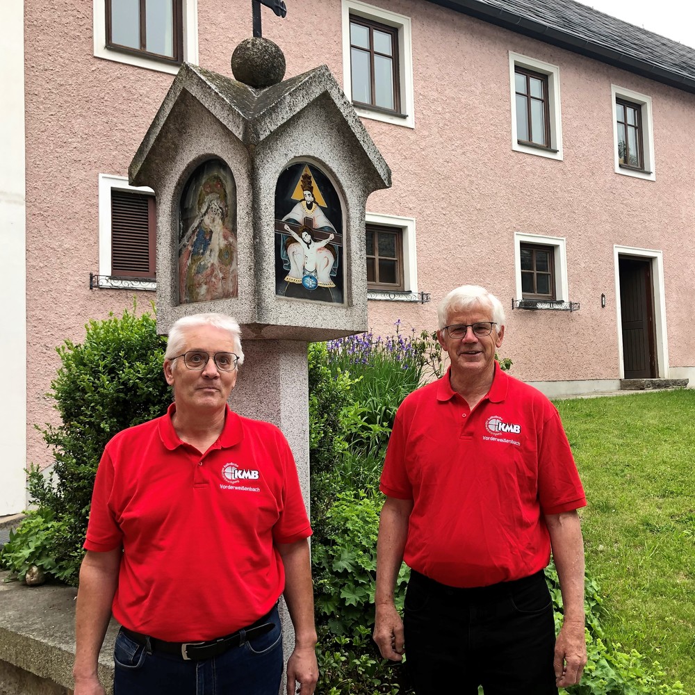 Kurt Neundlinger und Herbert Kaar mit KMB.T-Schirt beim Eingang zum Pfarrheim