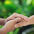 Couple holding hands in green meadow.